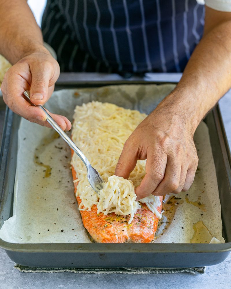 Covering the cooked trout fillet with celeriac crème fraiche mix