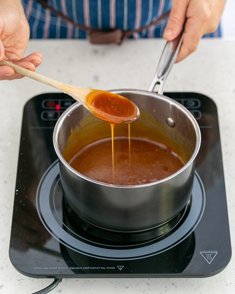 Showing prepared salted caramel with a wooden spoon