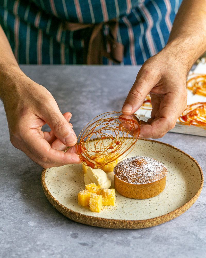 Decorating the caramel fondant with mint leaves and caramel decoration