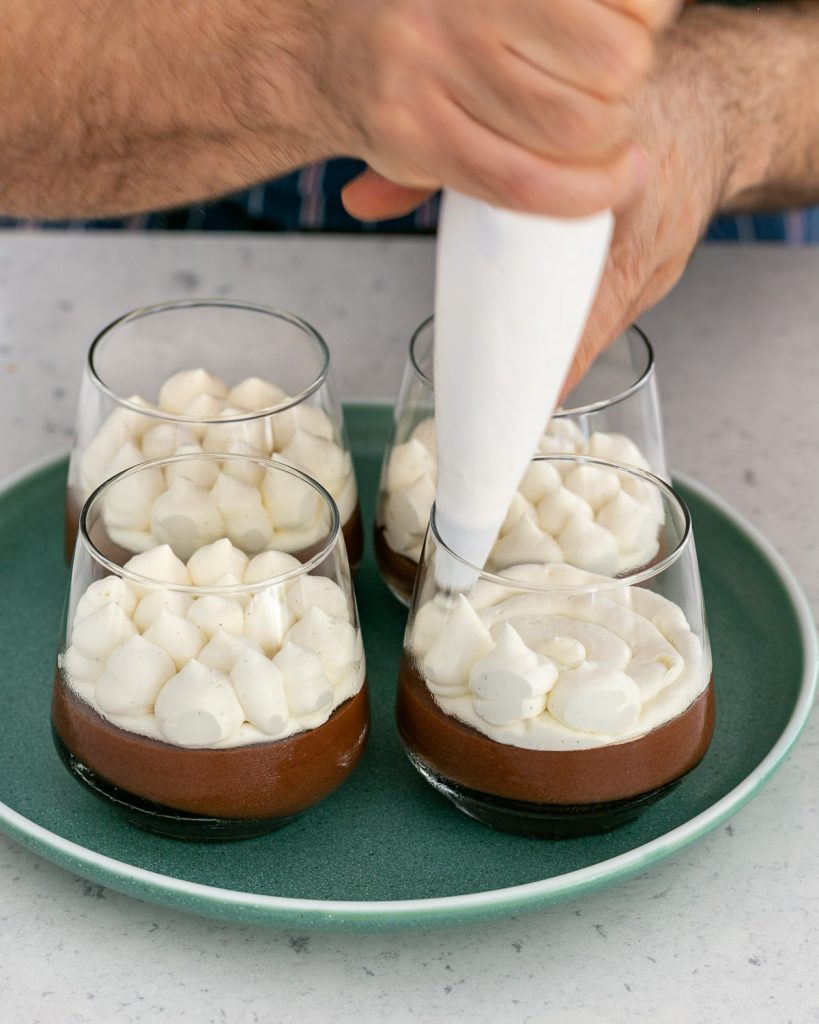 Making spikes of whipped cream  on chocolate mousse using a piping bag