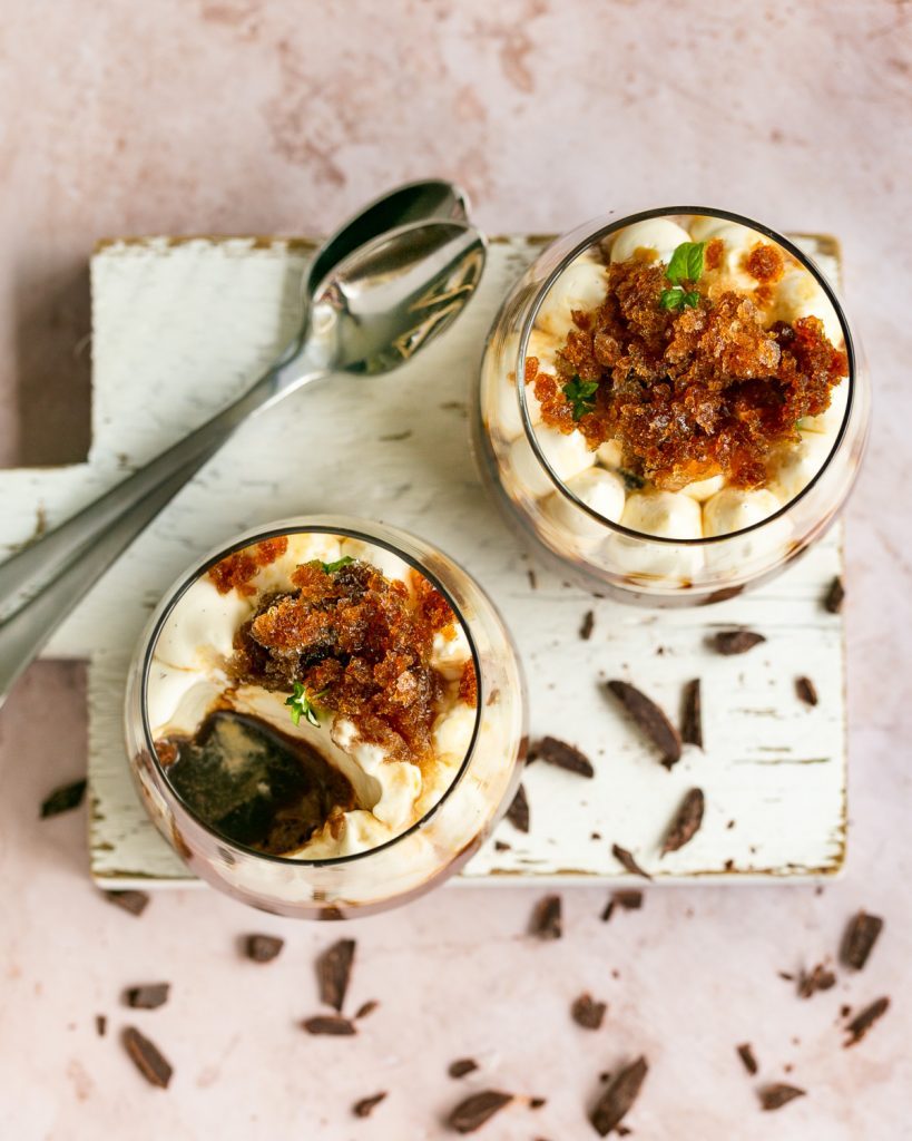 Dark Chocolate Mousse with Coffee granita in two dessert glasses with spoons on the side