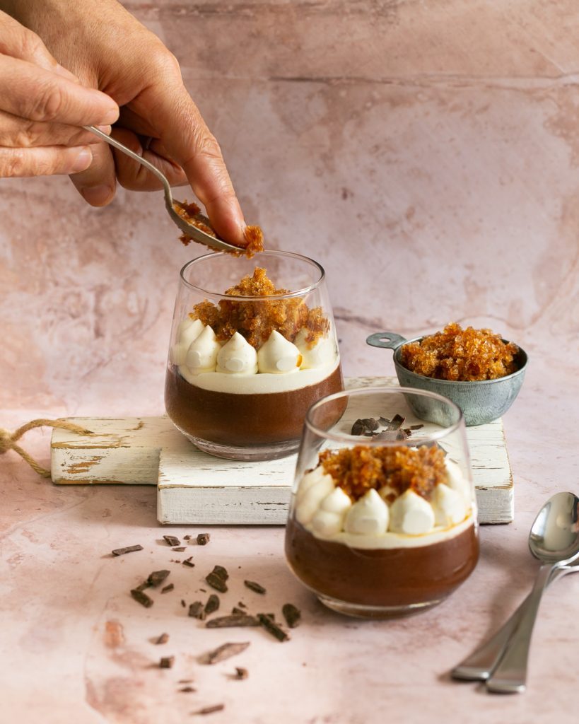 Garnishing the dark chocolate mousse with coffee granita