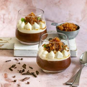 dark chocolate mousse dessert with whipped cream and coffee granita in two dessert glasses