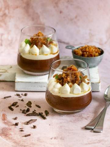 dark chocolate mousse dessert with whipped cream and coffee granita in two dessert glasses