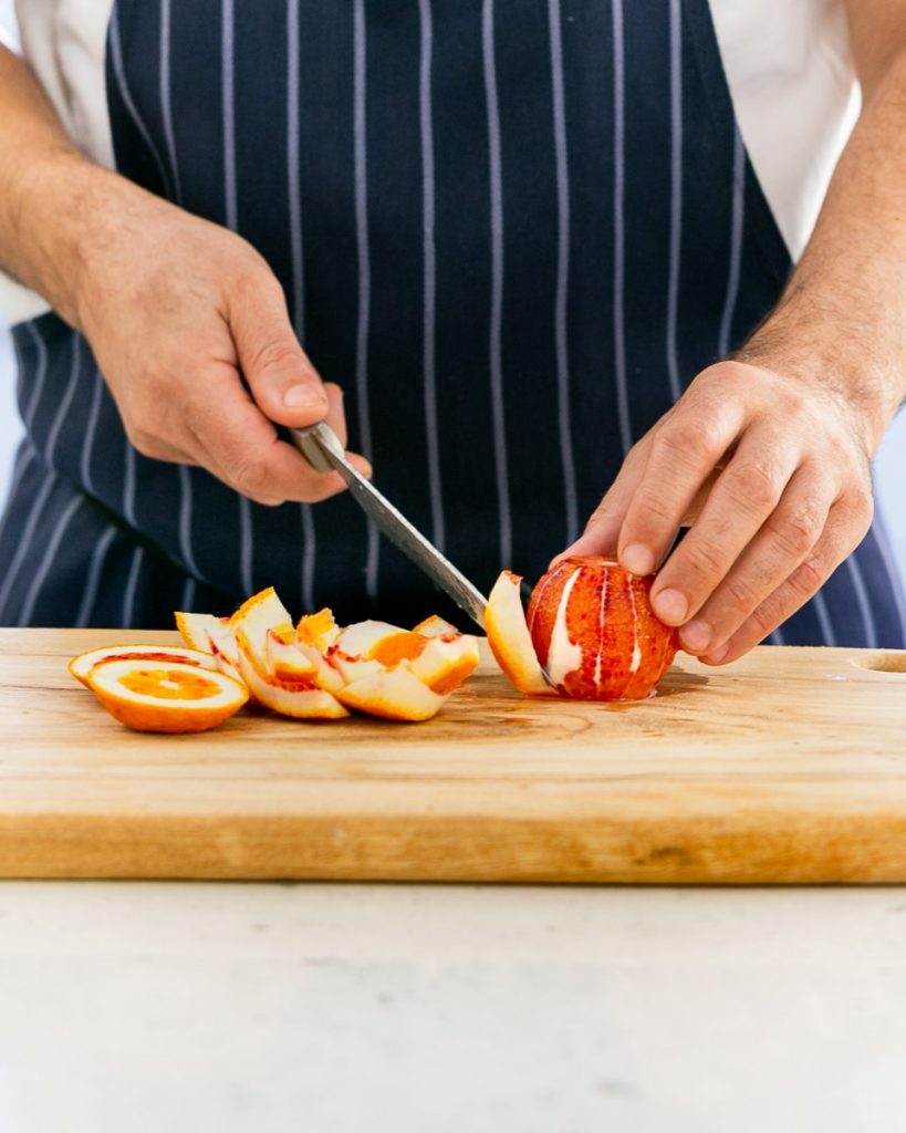 Peeling a blood orange with a knife