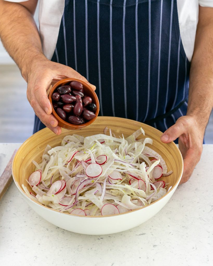 Kalamata olives added to the salad bowl