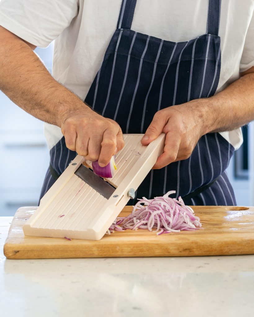 Slicing red onion on a Japanese mandoline