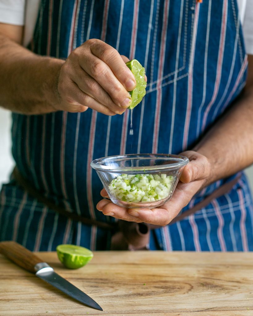 Adding lime zest and juice to the dices apples for garnishing the oven baked scallops