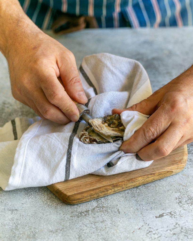 Shucking raw oysters with an oyster knife