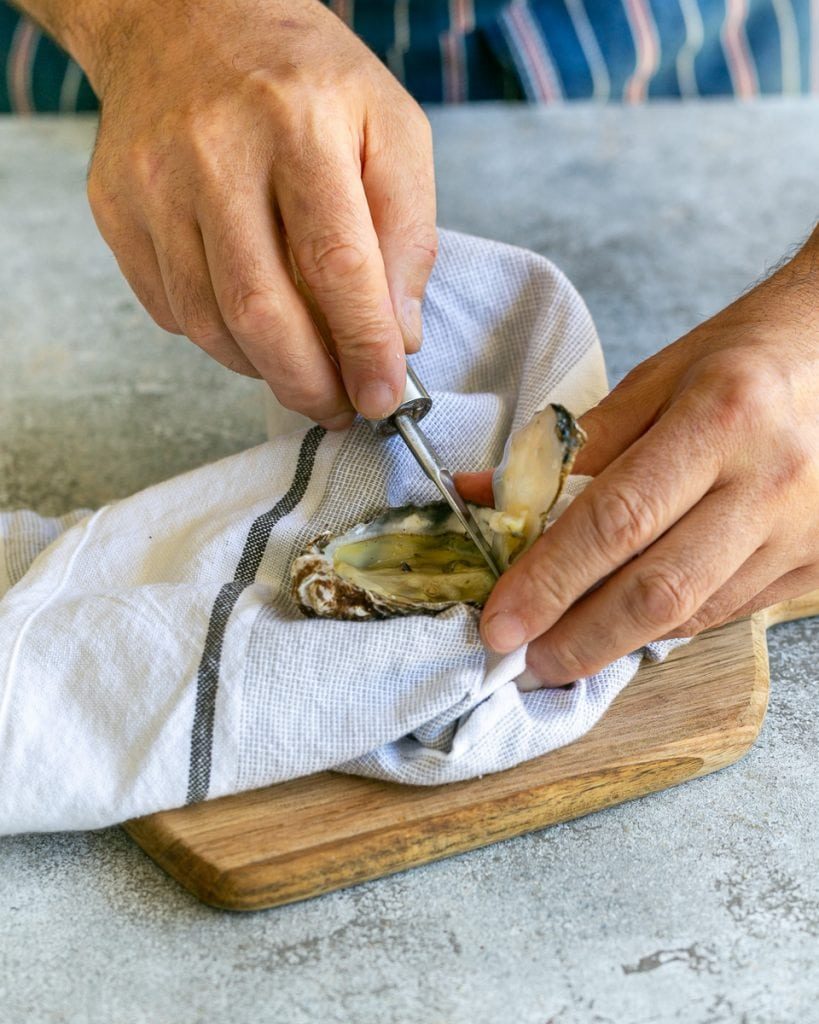 Shucking raw oysters with an oyster knife