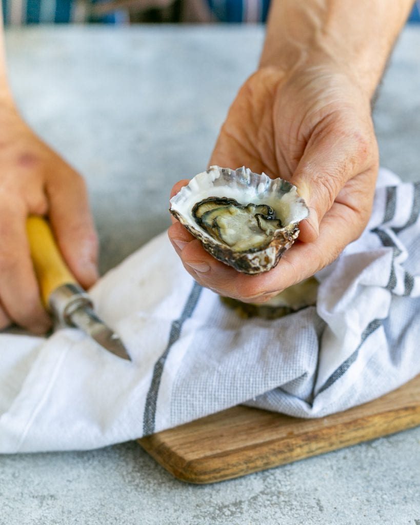 Shucking raw oysters with an oyster knife