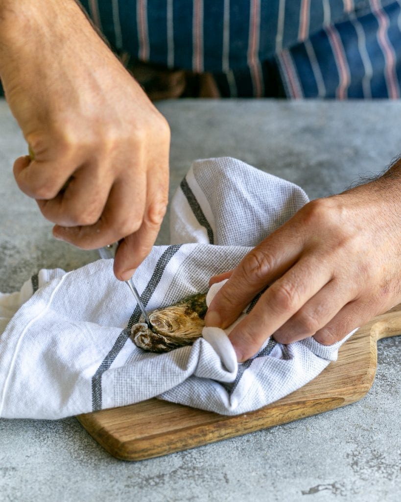 Shucking raw oysters with an oyster knife