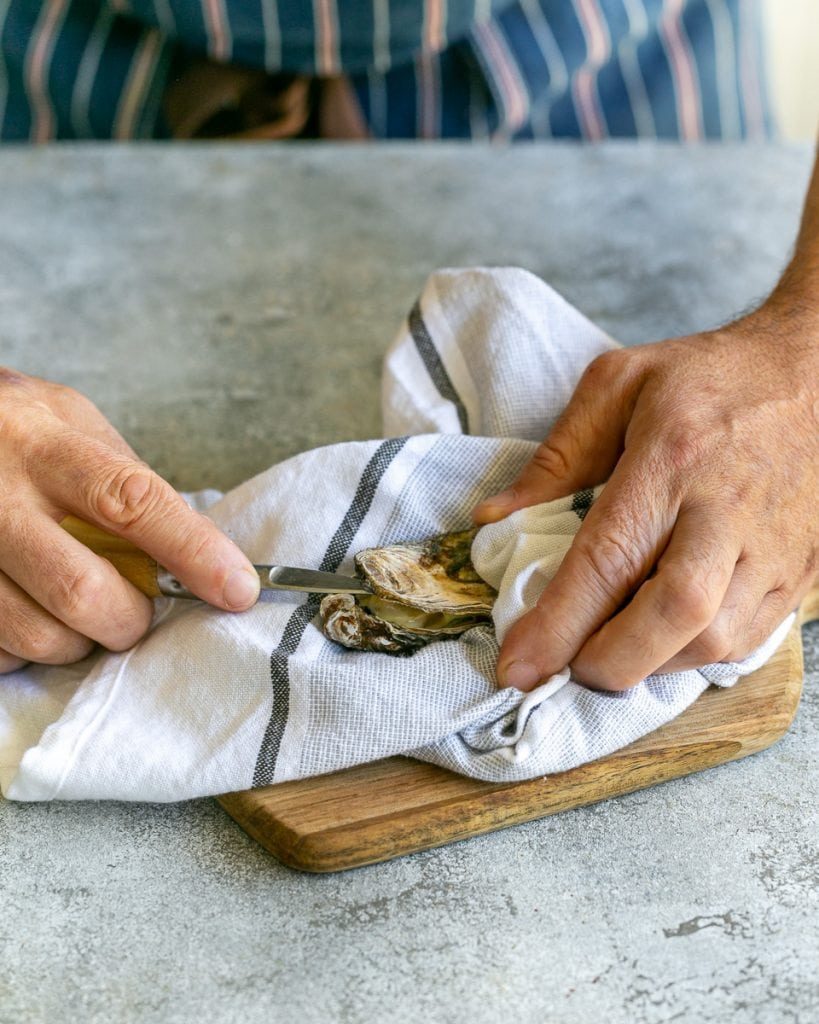 Shucking raw oysters with an oyster knife