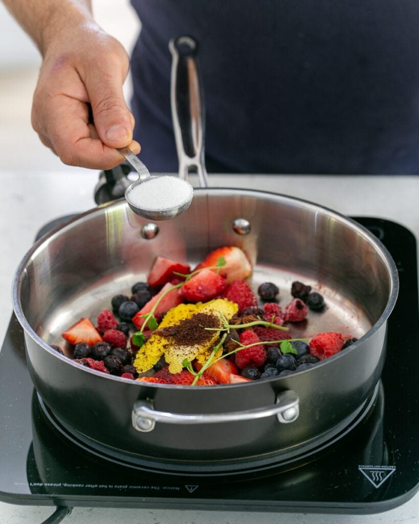 Adding sugar to berry soup