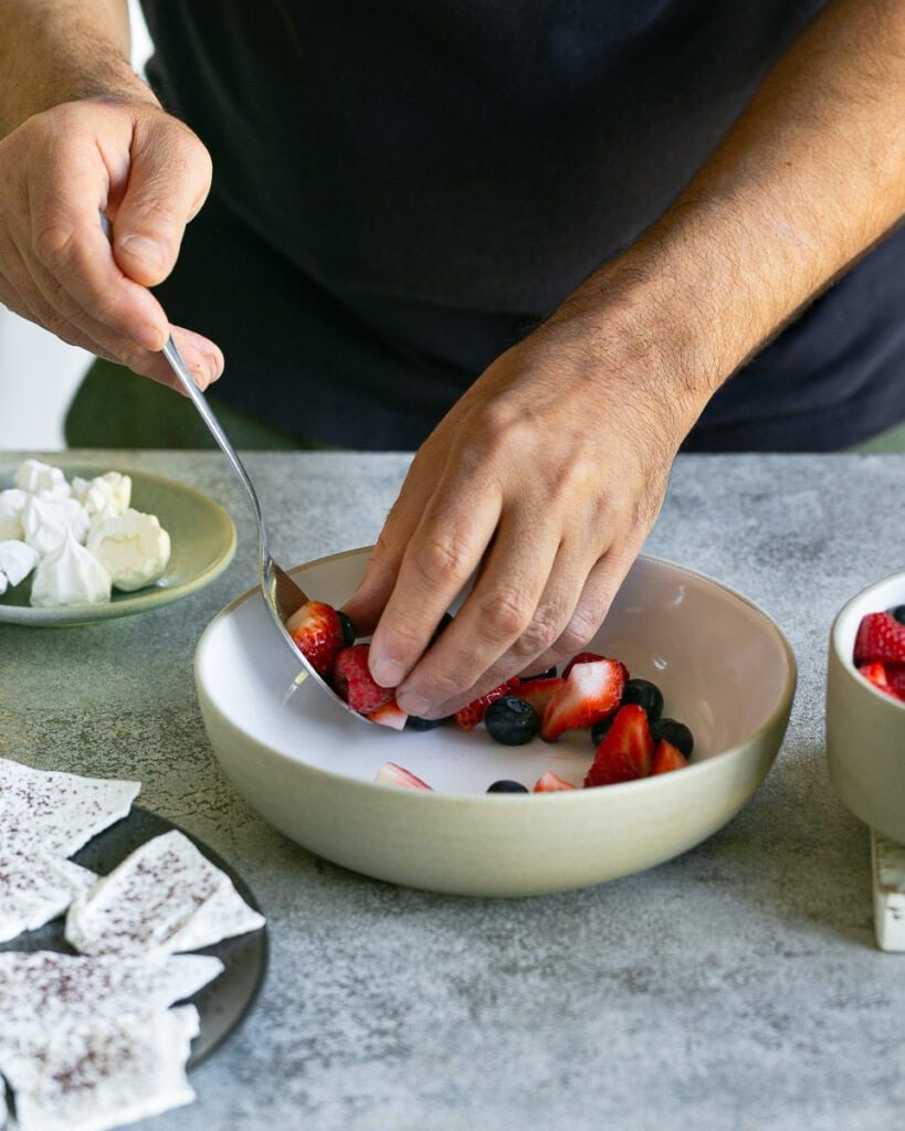 Arranging the mixed berries in a bowl