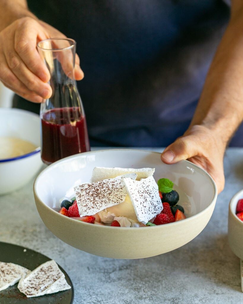 White chocolate Mousse with mixed berries plated in a bowl with berry soup on the side