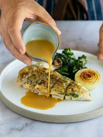 Chicken gravy served with roasted chicken breasts and kale edited