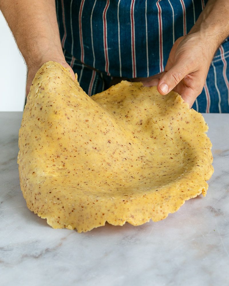 rolled out dough in tart baking pan