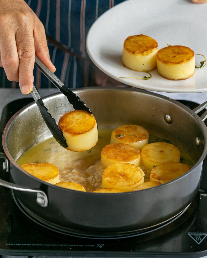 Taking out the cooked potatoes from the stock to make glaze