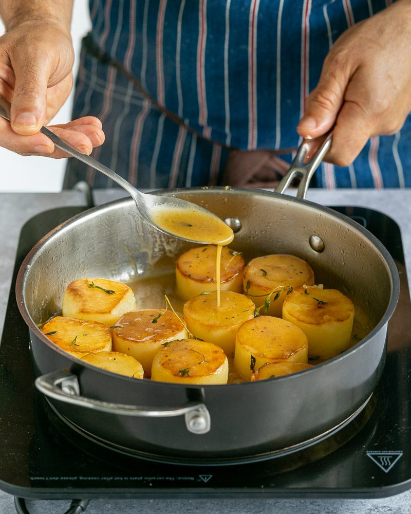 Spooning the reduction over the potato for more flavour