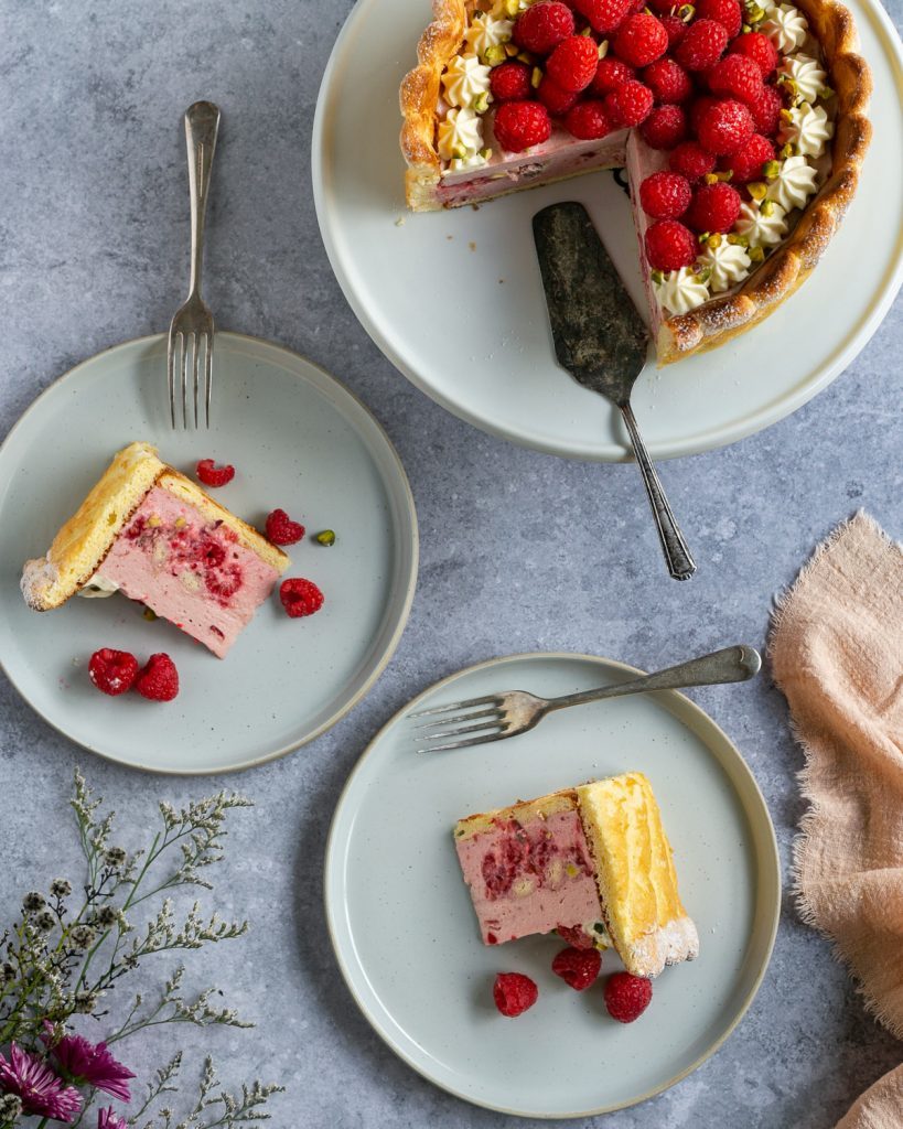 two slices served on plates with the charlotte cake in the bacground