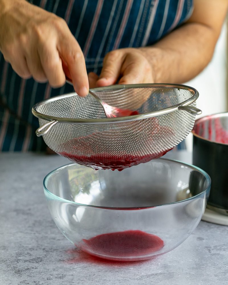 Straining the cooked raspberry to make the coulis