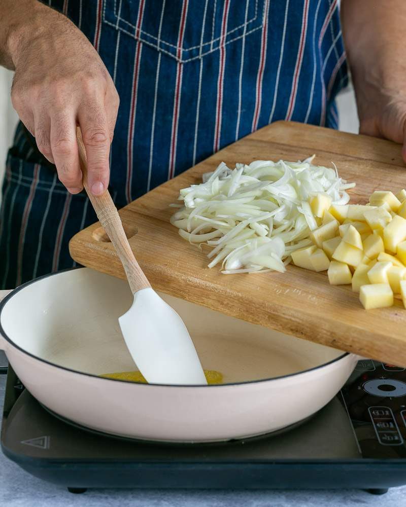 Adding onions and apples to a pan