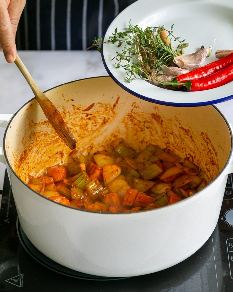 Adding chillies, while garlic and fresh herbs