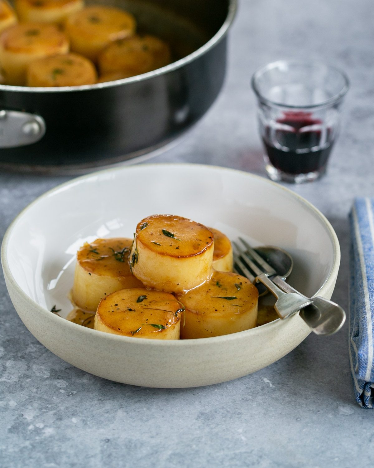 Fondant potatoes served from a pan in a bowl