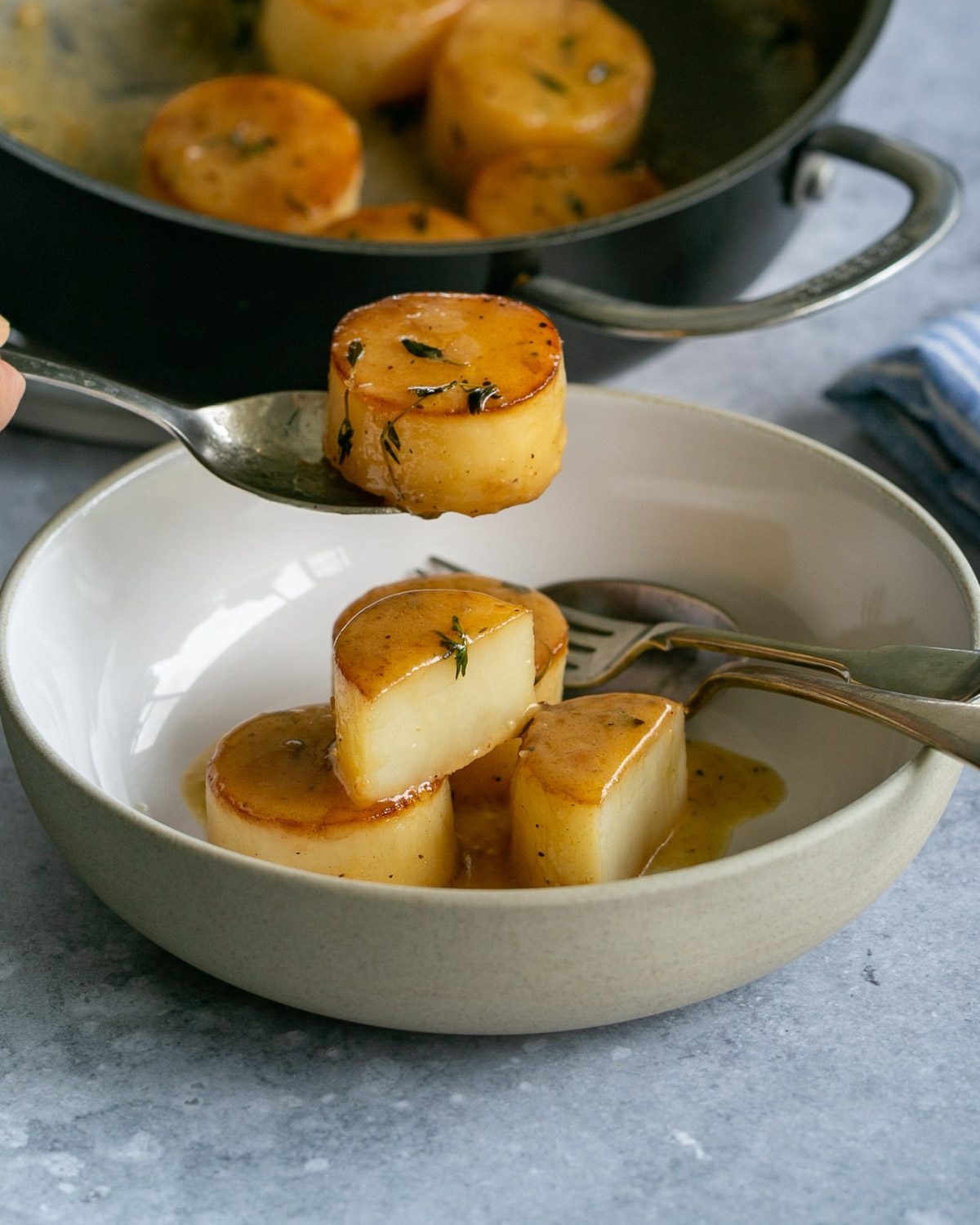 Fondant potatoes served from a pan in a bowl