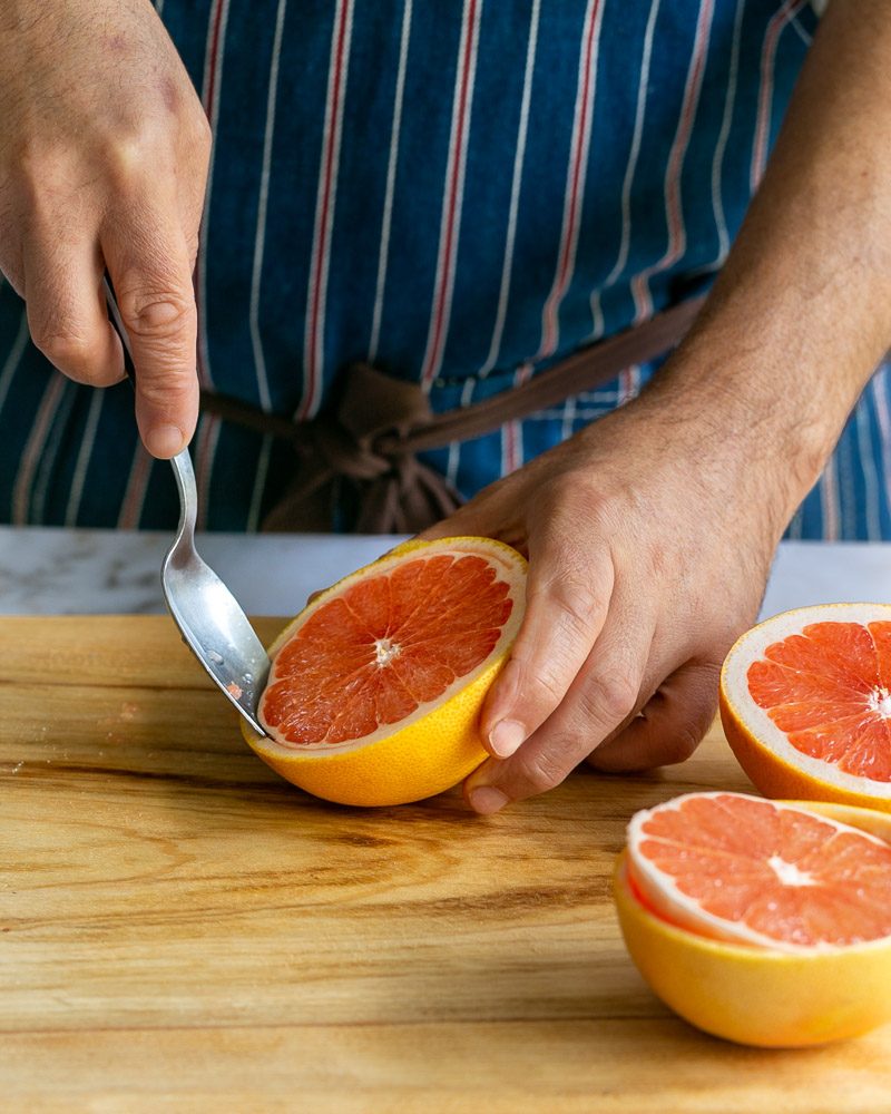 Scooping the grapefruit from the grapefruit skin