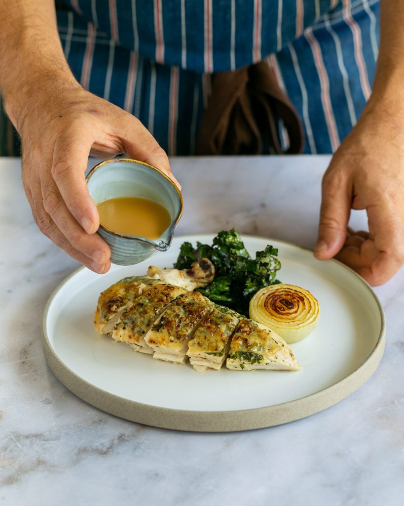 Serving Sliced chicken breasts with crispy kale and chicken gravy