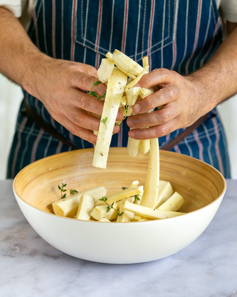Tossing cut parsnip in olive oil and seasoning