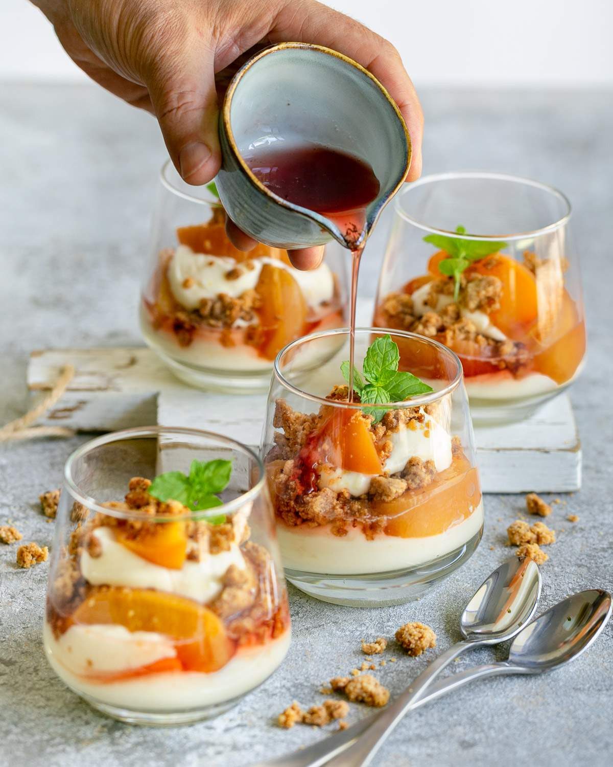 Adding reduced poaching liquid to the dessert in glass