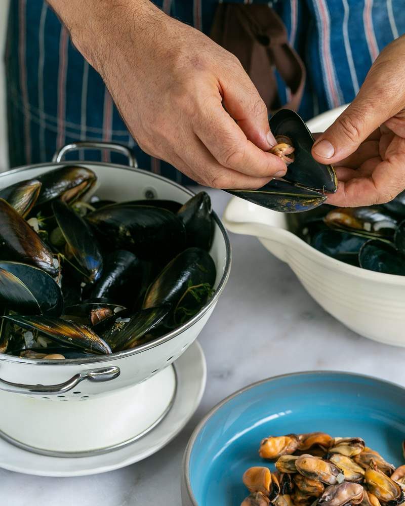 Taking out the cooked mussels from the shell