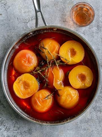 Poached peaches in a pan