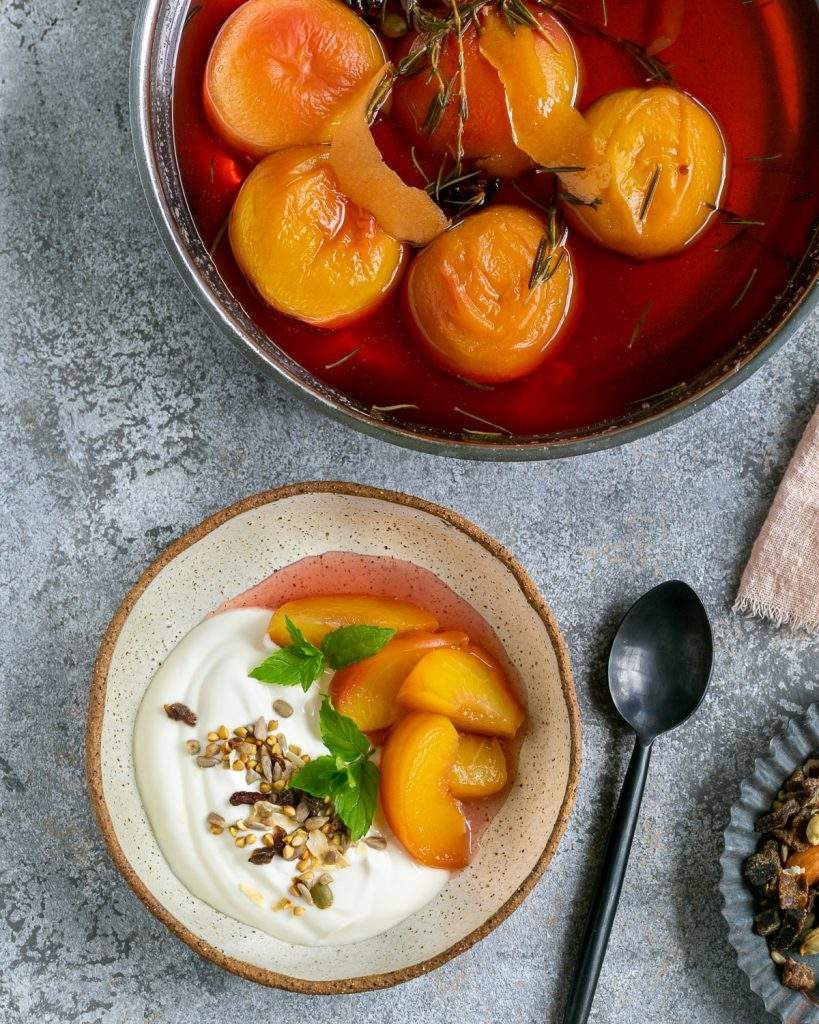 Poached peaches served with yoghurt and nuts