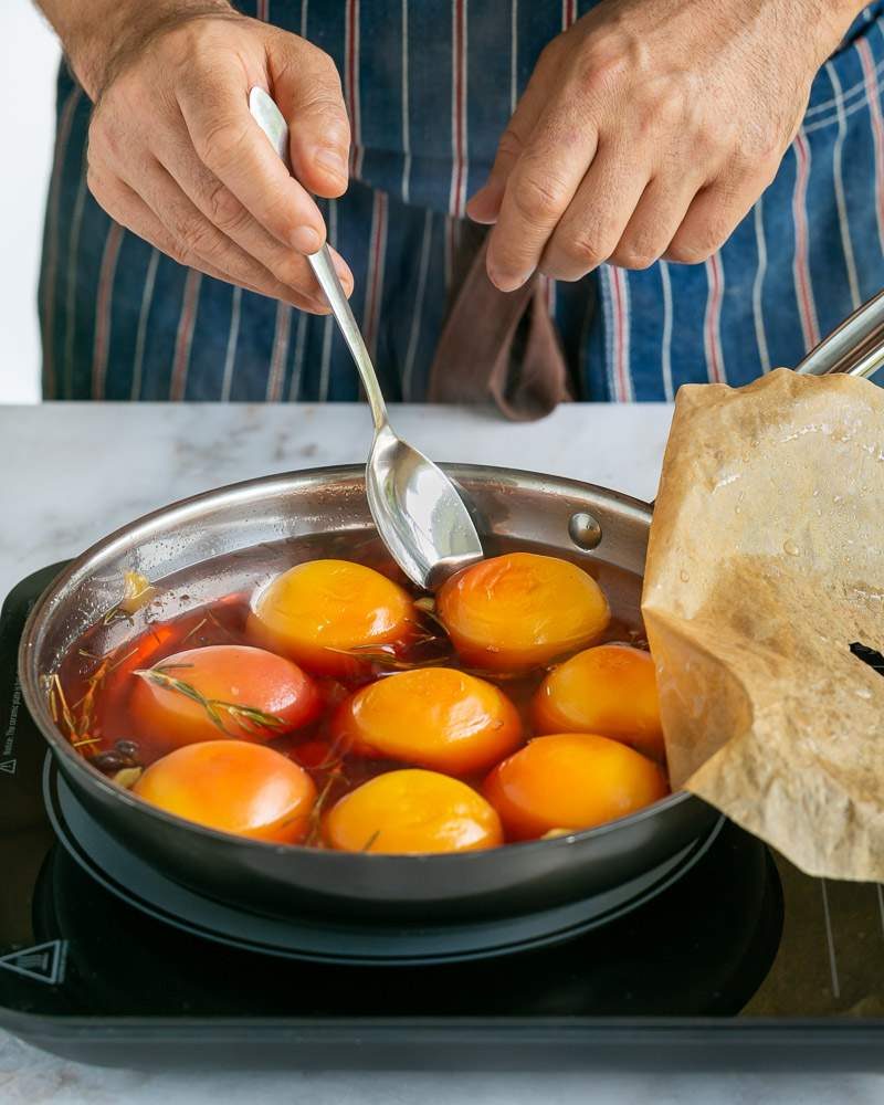 taking out poached peaches with a spoon