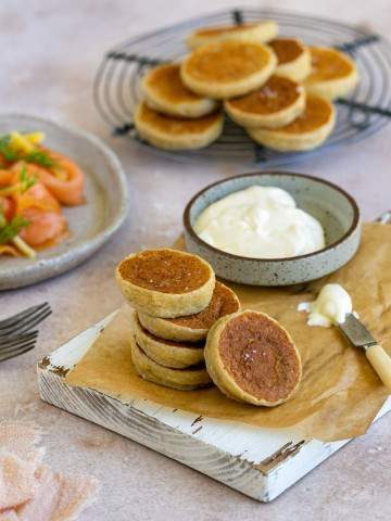 Potato Blinis stacked on a wooden board