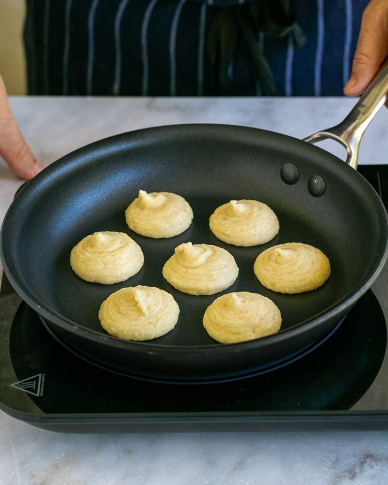 Piping blinis batter in pan