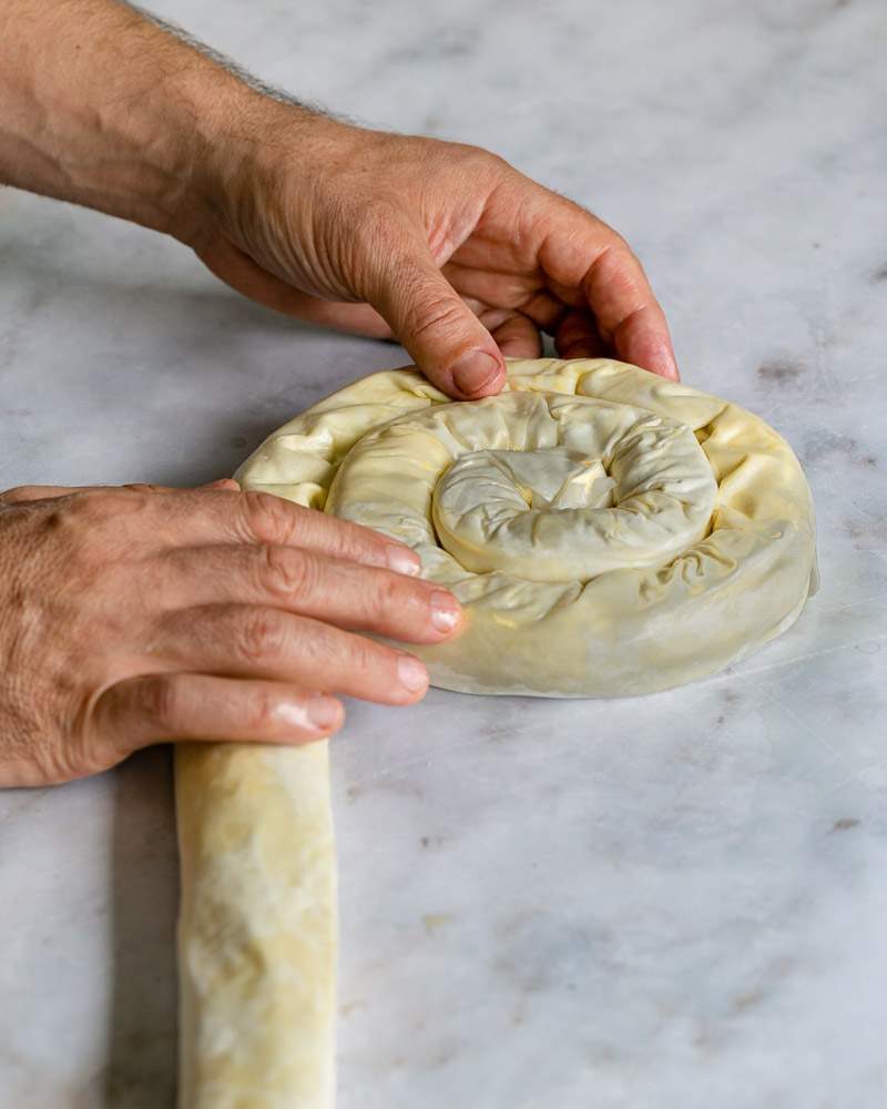 Rolling the stuffed filo into a spiral