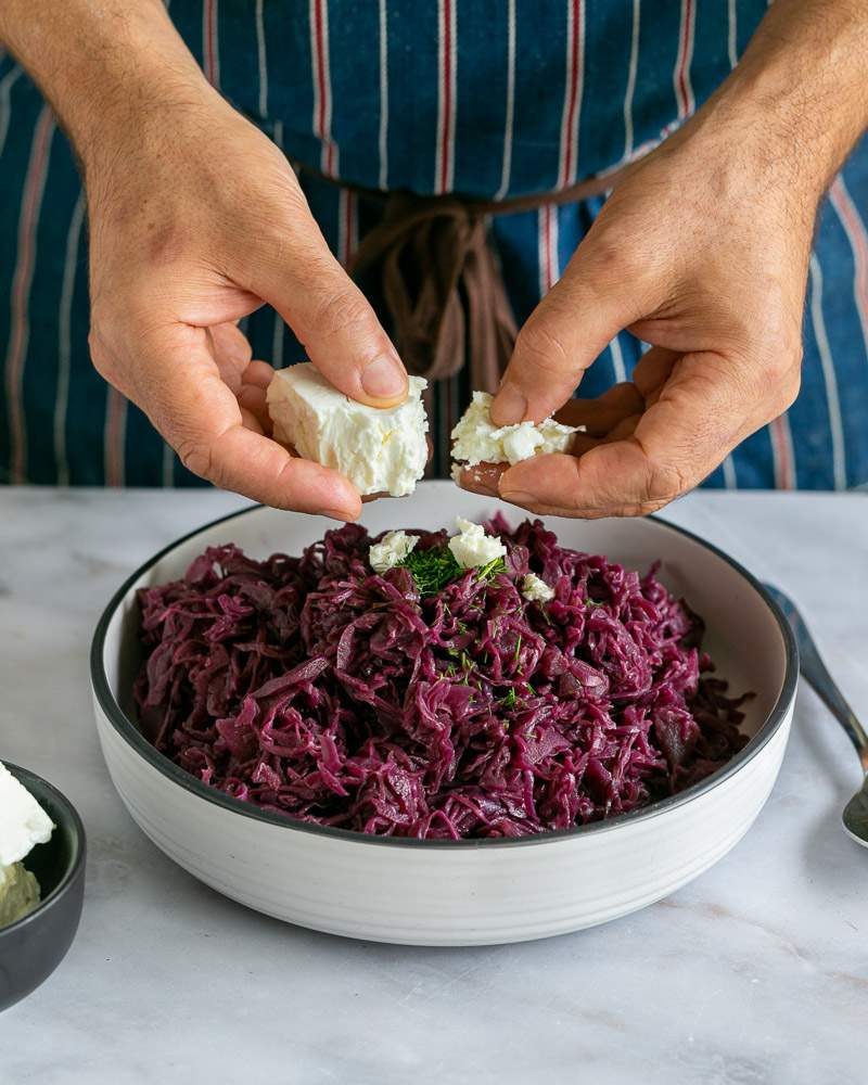Crumbling feta cheese into the red cabbage