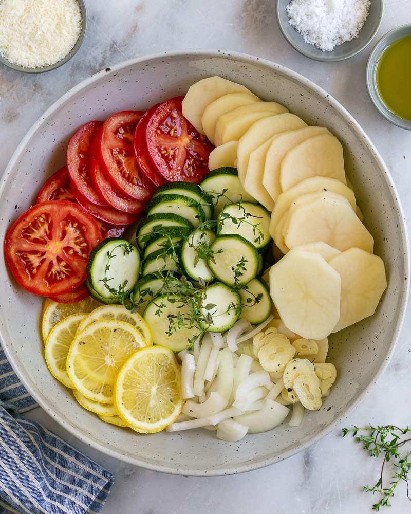 Vegetables mixed with seasoning and herbs in a bowl