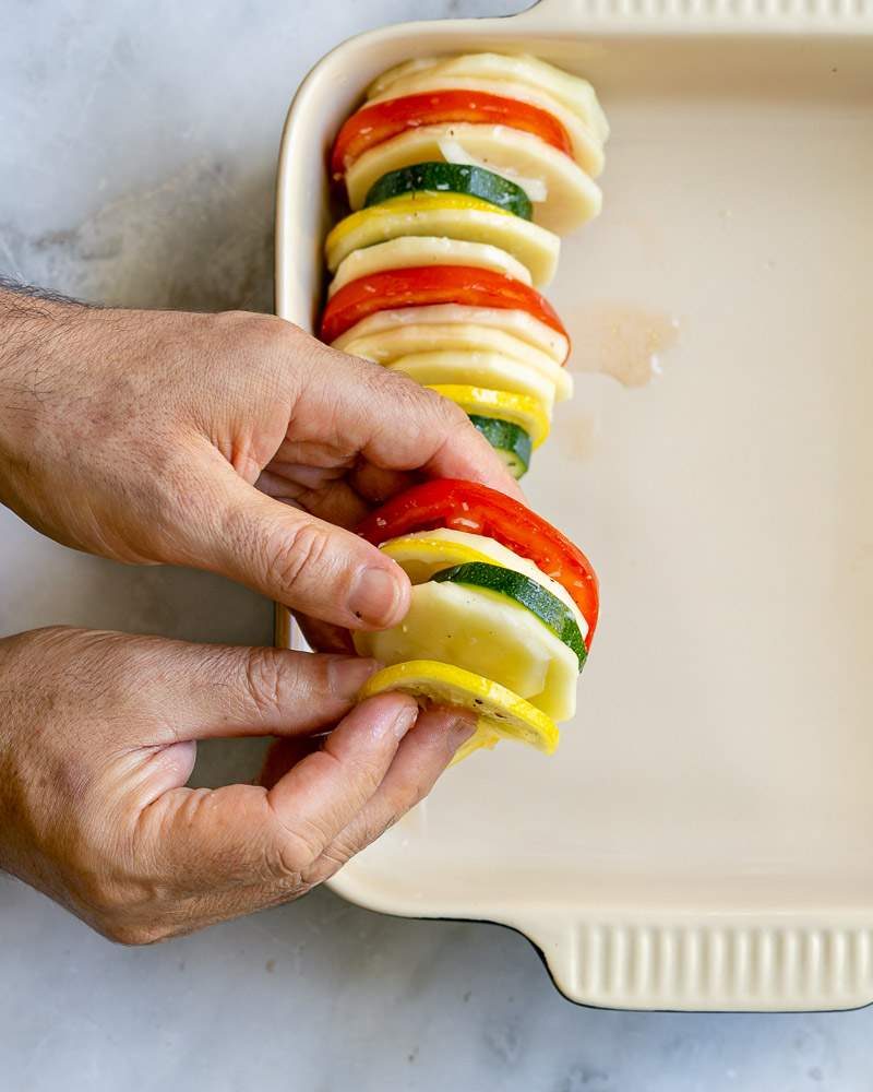 Stacking sliced vegetables in the baking dish