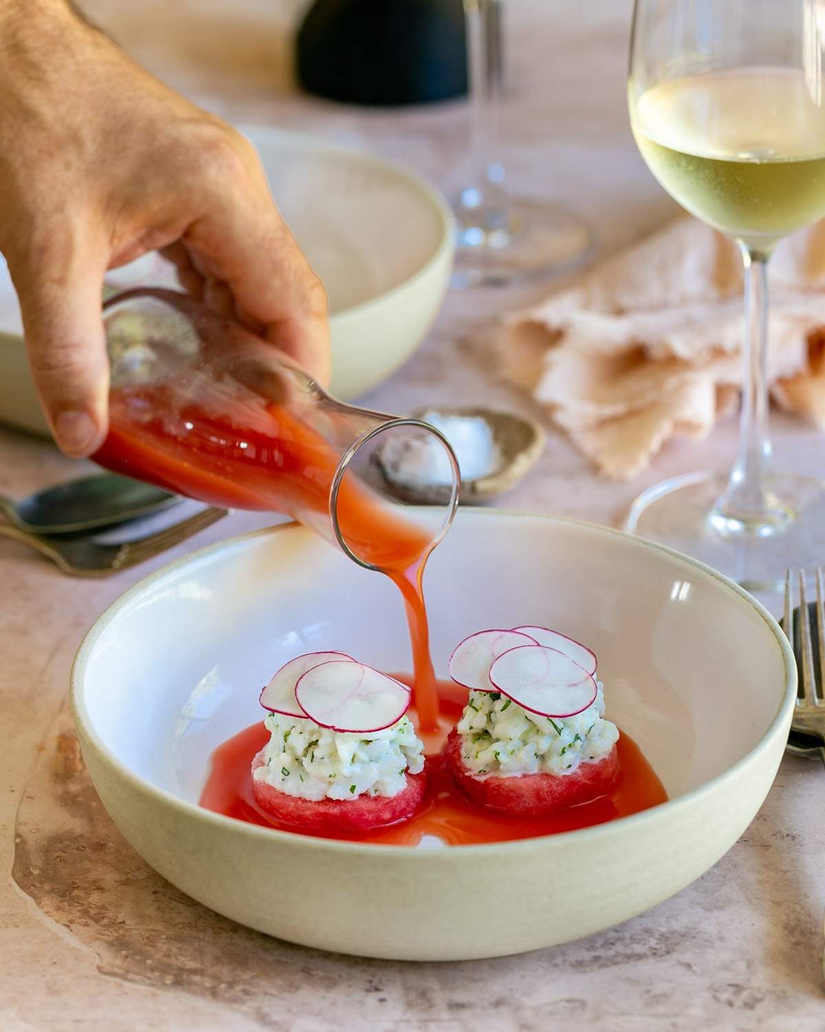 Watermelon gazpacho poured into bowl