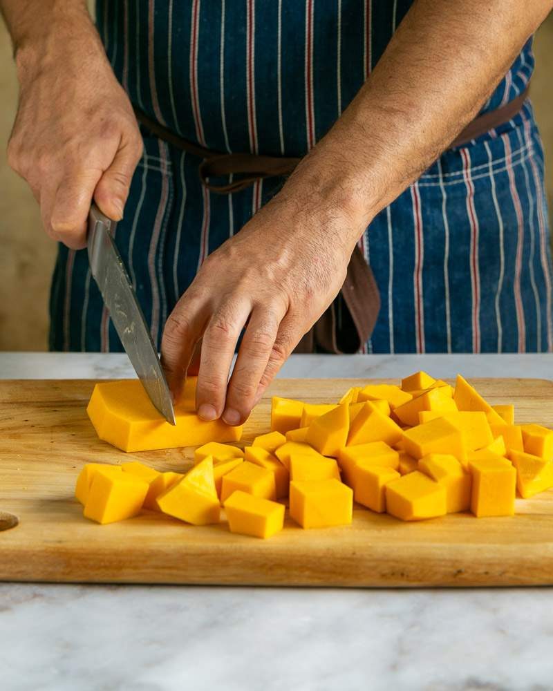 Large cubes of pumpkin on chopping board for roasting