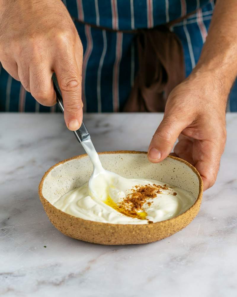 Mixing yoghurt with cumin and olive oil