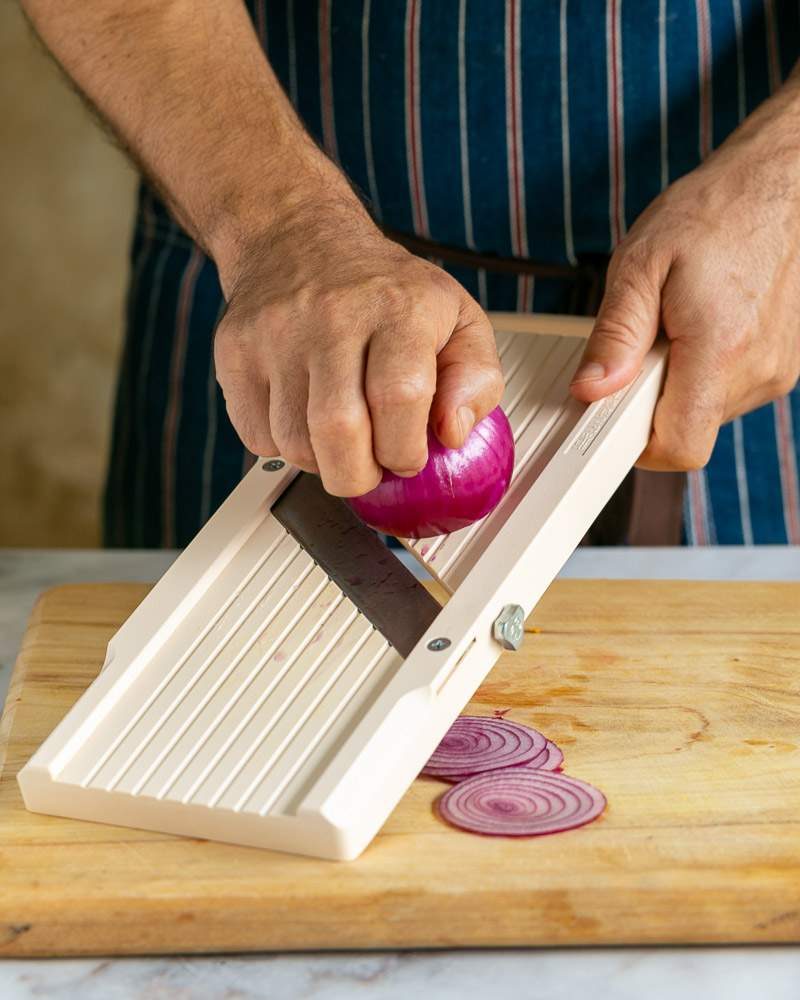 Slicing onions on a mandoline