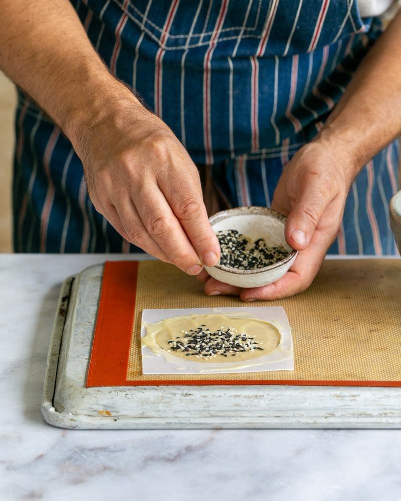 Sprinkling sesame on tuile batter