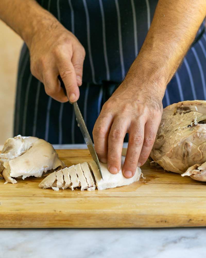 Cutting cooked chicken for ramen